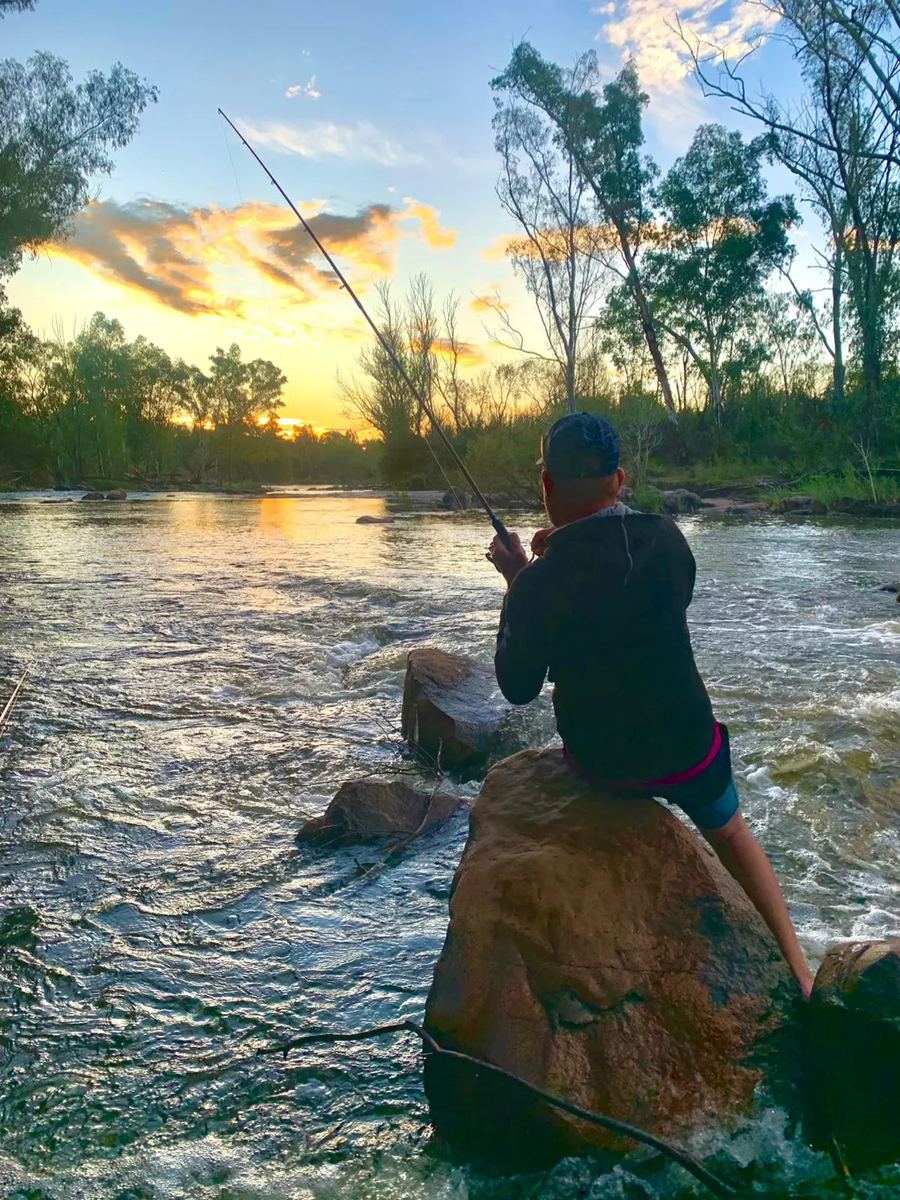 Fishing from a rock at sunset
