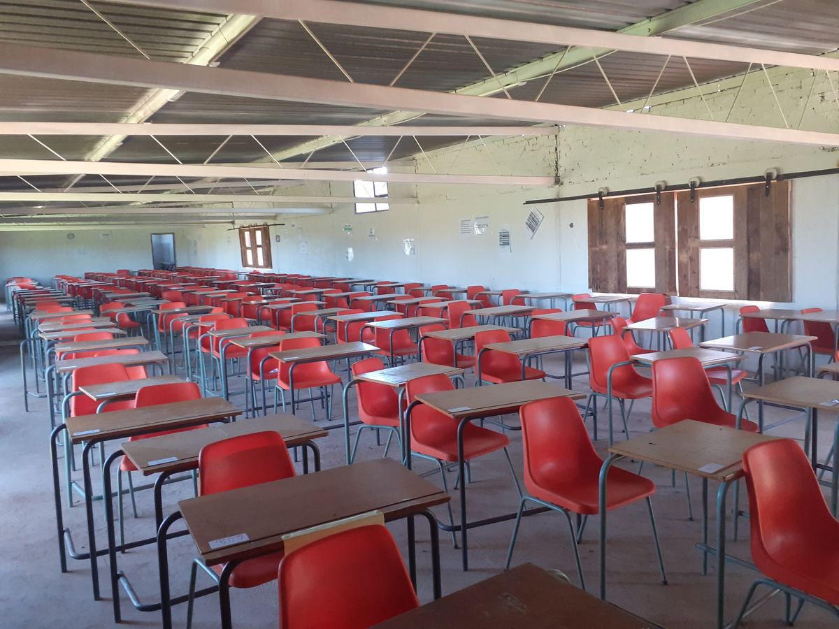 Hall set up with rows of tables and red chairs