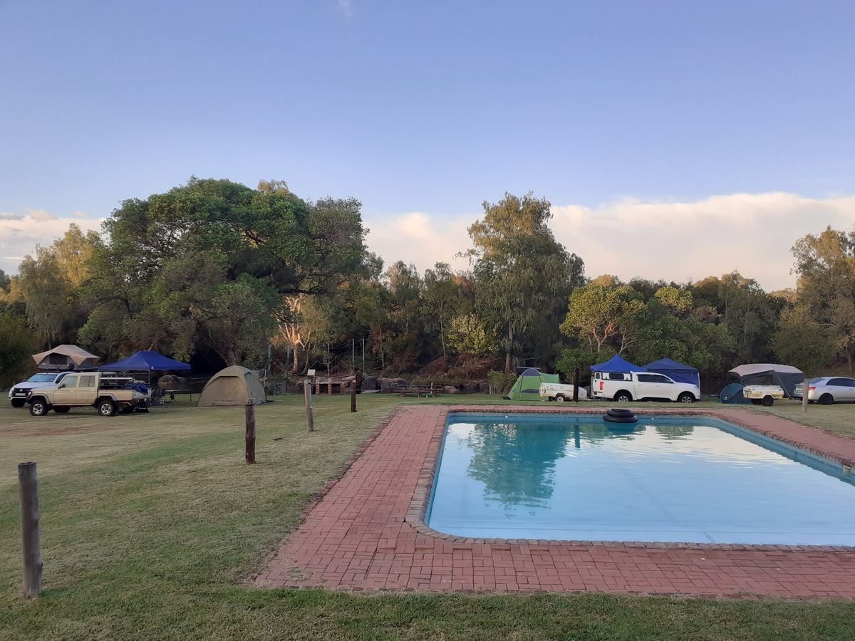 Swimming pool with tents and caravans behind